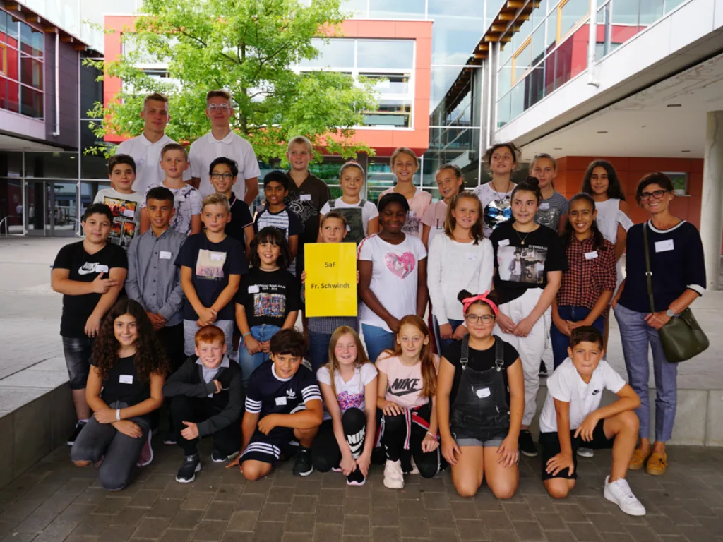 Klassenfoto einer neuen fünften Klasse mit gelbem Schild.